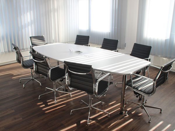 A boardroom with a long table and leather chairs