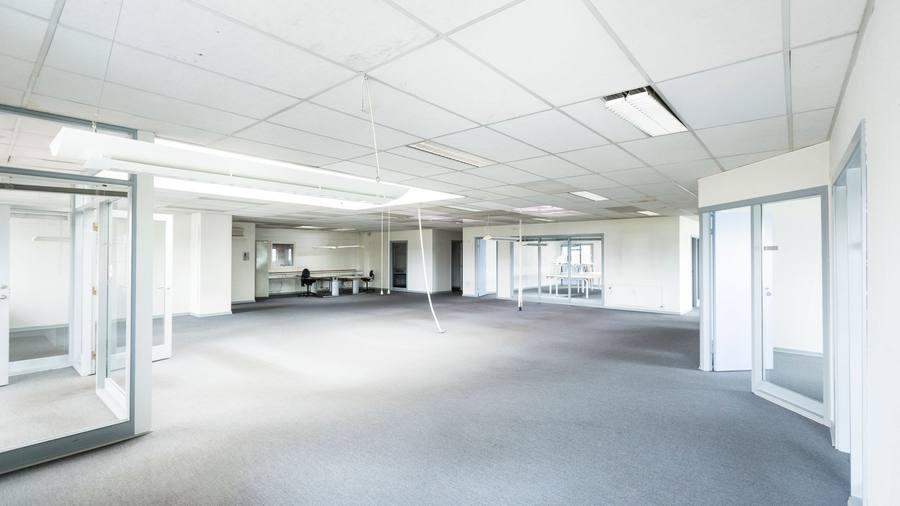 A bright, empty office interior with glass partitions