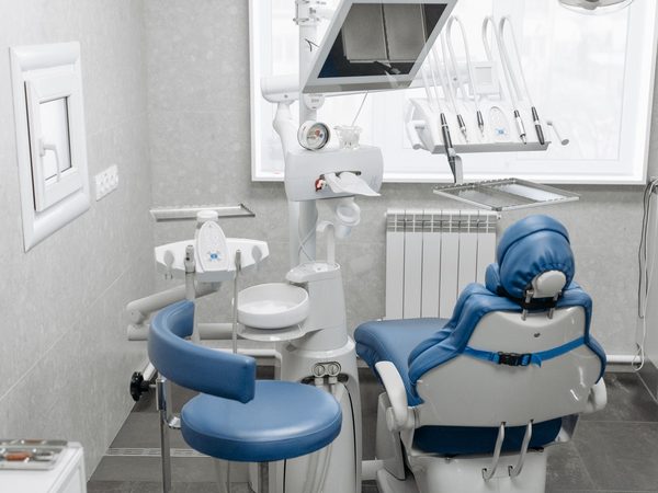 A modern dental operatory with a dental chair, light and delivery unit